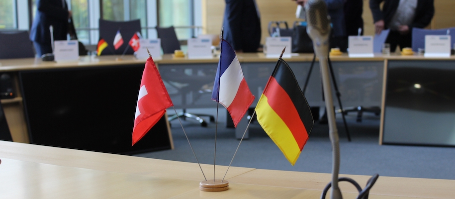 Miniaturflaggen Deutschlands, Frankreichs und der Schweiz auf dem Tisch eines Sitzungsraumes