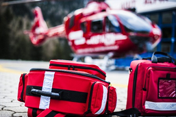 Des matériaux de médécin et un hélicoptère en arrière fond, lien : thème aide médicale urgente
